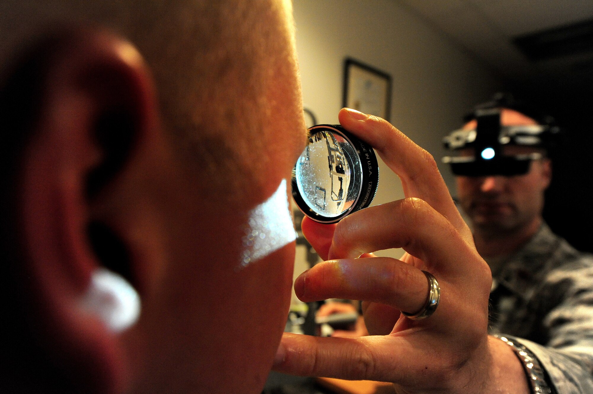 Dr. (Maj.) Michael Bogaard, 509th Medical Operations Squadron optometrist, uses a binocular indirect ophthalmoscope to perform an eye assessment on Senior Airman Jeffrey Afemon, 509th MDOS public health technician, in the optometry clinic at Whiteman Air Force Base, Mo., Sept. 4, 2013. The ophthalmoscope helps focus the light inside the patient’s eye and provides an image that the doctor uses to judge the health of the retina. (U.S. Air Force photo by Staff Sgt. Nick Wilson/Released)