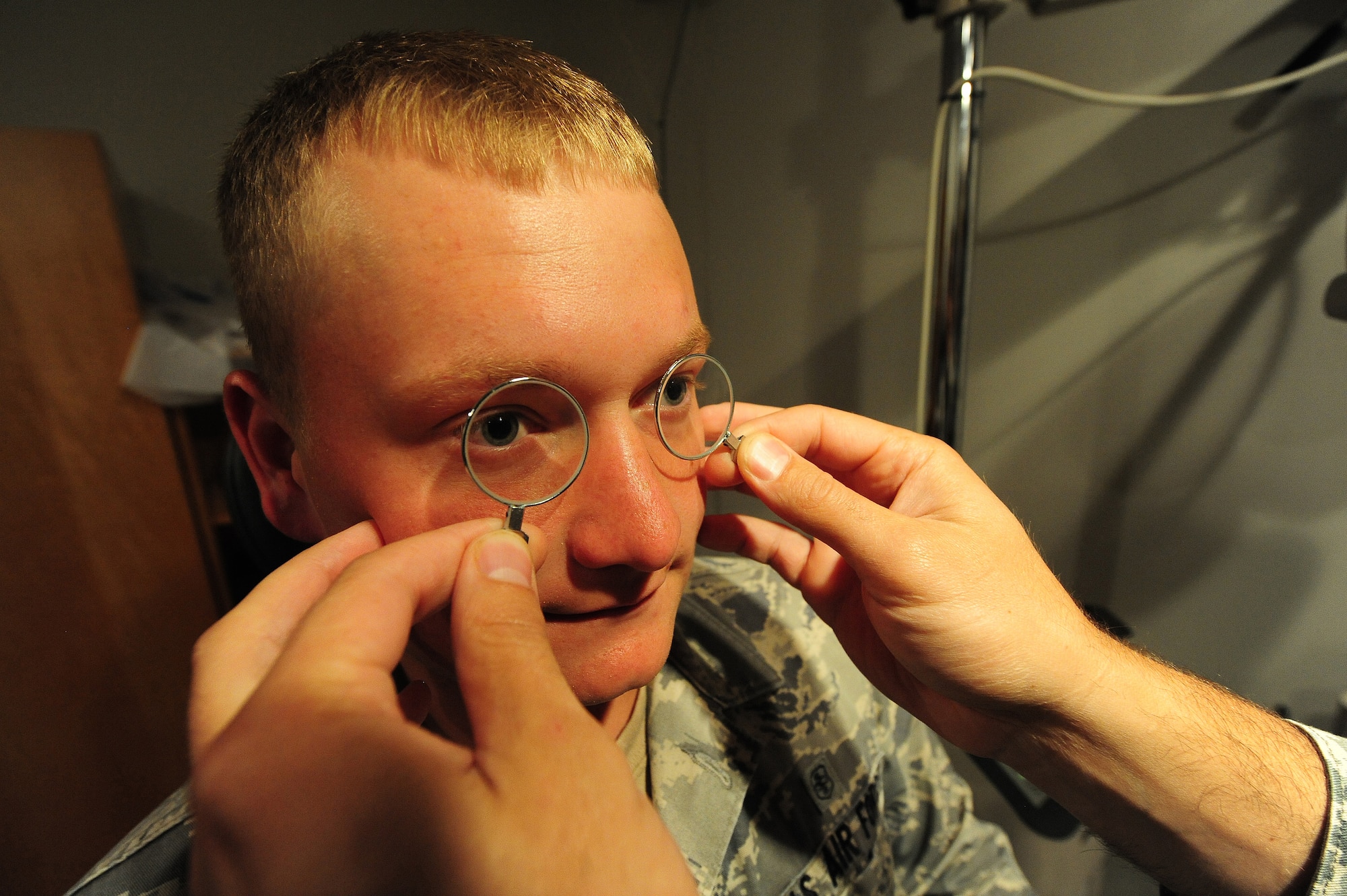 Dr. (Maj.) Michael Bogaard, 509th Medical Operations Squadron optometrist, holds up a set of trial lenses to the eyes of Senior Airman Jeffrey Afemon, 509th MDOS public health technician, in the optometry clinic at Whiteman Air Force Base, Mo., Sept. 4, 2013. The lenses help demonstrate to the patient what prescription they’ll be getting. (U.S. Air Force photo by Staff Sgt. Nick Wilson/Released) 