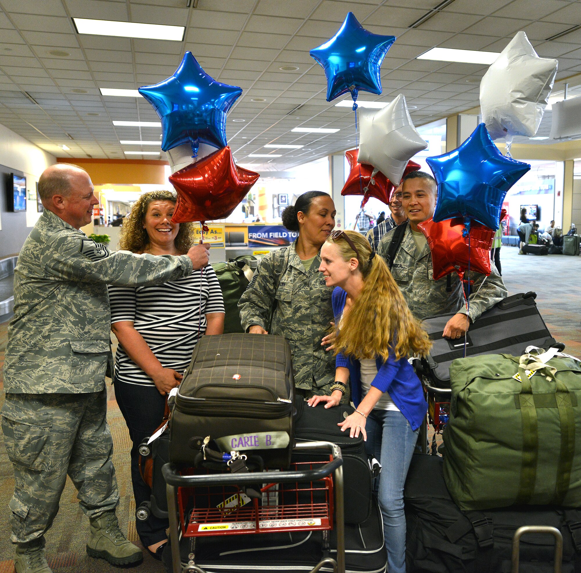 WRIGHT-PATTERSON AIR FORCE BASE, Ohio – Maj. Romeo Cabungcal, 445th Aeromedical Evacuation Squadron flight nurse along with Master Sgts. Brad Eckhart and Carie Brown, also assigned to the 445 AES, arrive at the at Dayton International Airport upon their return from a six-month deployment Sept. 26, 2013. The trio was part of medical evacuation teams flying patients from downrange, to Germany and the United States. (U.S. Air Force photo/Tech. Sgt. Frank Oliver)