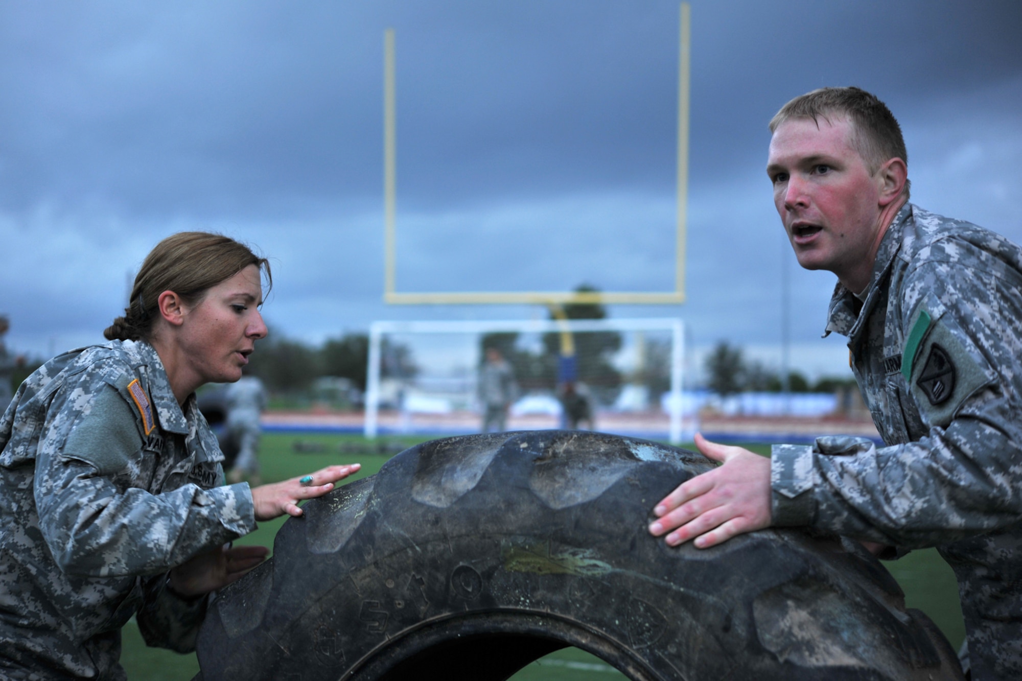 GOODFELLOW AIR FORCE BASE, Texas-- Army Spcs. Rachel Schwartz and Garrett Stagner, 344th Military Intelligence Battalion Students, flip a tire during the Iron Soldier Competition Oct. 26. The competition is designed to promote esprit de corps throughout the unit and place increased emphasis on teamwork and mission accomplishment. (U.S. Air Force photo/ Senior Airman Michael Smith)