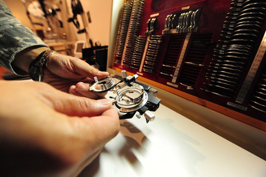 Dr. (Maj.) Michael Bogaard, 509th Medical Operations Squadron optometrist, adjusts a trial frame in the optometry clinic at Whiteman Air Force Base, Mo., Sept. 4, 2013. The frame and lenses help show patients what their new eyeglass prescription will look like before they receive them. (U.S. Air Force photo by Staff Sgt. Nick Wilson/Released)