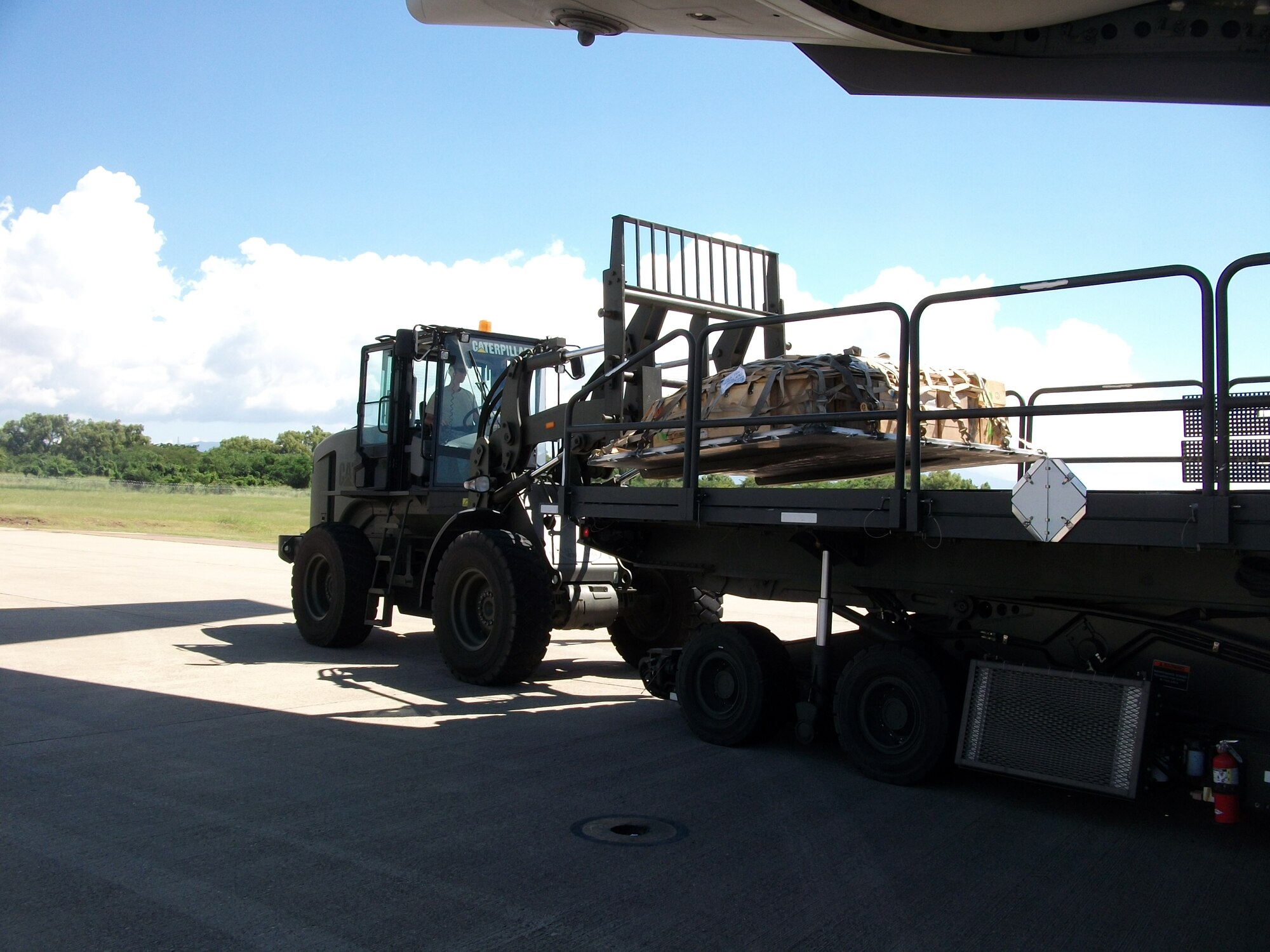 Members of Joint Task Force-Bravo's 612th Air Base Squadron offload cargo from a C-17 Globmaster III aircraft from Charleston Air Force Base, S.C, on the flightline at Soto Cano Air Base, Honduras, Nov. 3, 2013.  The 612 ABS provides a day and night, all-weather, C-5 capable airfield, base operations support, air traffic control, weather, crash and fire rescue, logistics and base civil engineers to support theater-wide USSOUTHCOM operations. (U.S. Air Force photo by Tech. Sgt. Stacy Rogers)