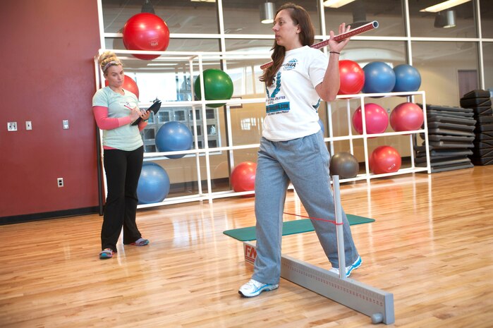 Kelley Welchert, 99th Aerospace Medicine Squadron Health and Wellness Center health and fitness specialist, conducts a hurdle step as Brittney Nishi, 99th AMDS HAWC health and fitness specialist measures Welchert’s hip flexibility and stability during a Functional Movement Screen at the Warrior Fitness Center Nov. 1, 2013, at Nellis Air Force Base, Nev. The Functional Movement Screen is designed to identify which movements or misalignments need to be corrected before a potential injury occurs. (U.S. Air Force photo by Staff Sgt. Christopher Hubenthal)