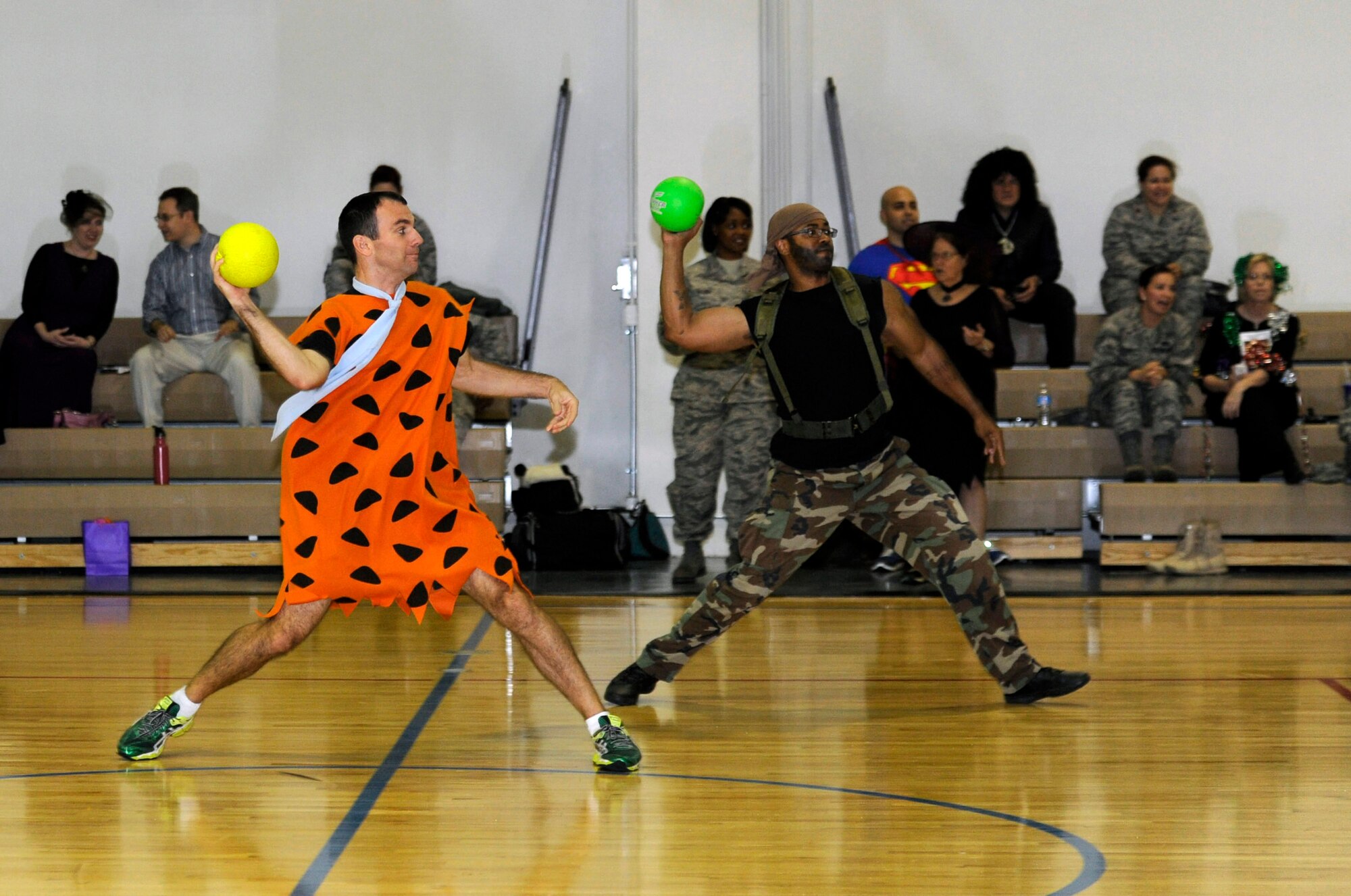 Capt. Dustin Kouba and Tech. Sgt. Christopher Frazier hurl dodge balls at opponents during Wingman Costume Dodge ball at the East Fitness Center on Joint Base Andrews, Md., Oct. 31 2013. Frazier, a Claims Paralegal and Kouba, a Special Victims Counsel, work for the Air Force Legal Operations Agency. (U.S. Air Force photo/ Airman 1st Class Nesha Humes)