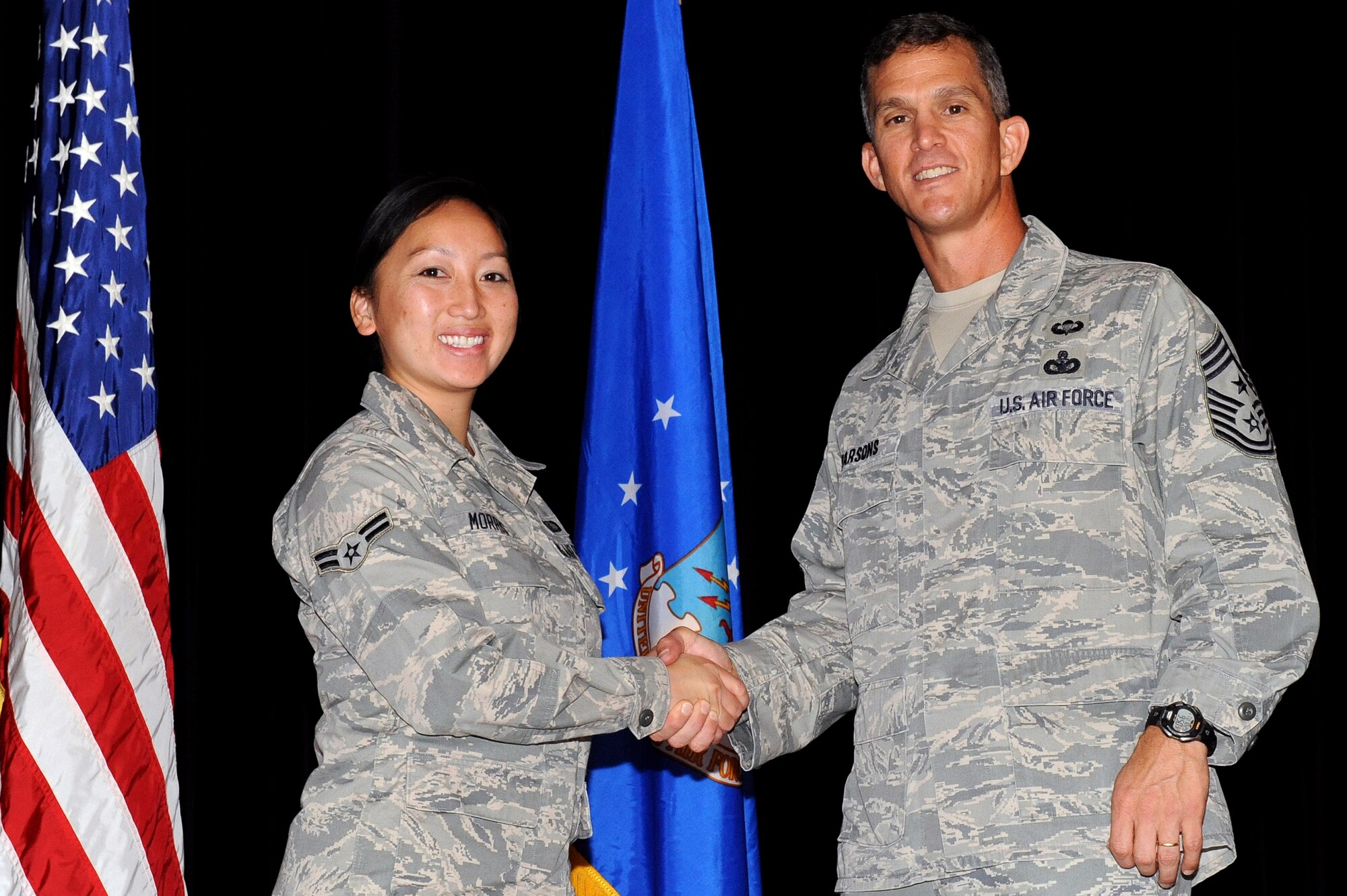 Airman 1st Class Sheng Morris, 4th Contracting Squadron contracting specialist, receives a coin for exceptional service from Chief Master Sgt. Richard Parsons, Air Combat Command command chief during a briefing at Seymour Johnson Air Force Base, N.C., Oct. 29, 2013. Sheng, along with five other Airmen, was recognized for her volunteerism and work ethic. (U.S. Air Force photo by Airman 1st Class Aaron J. Jenne)