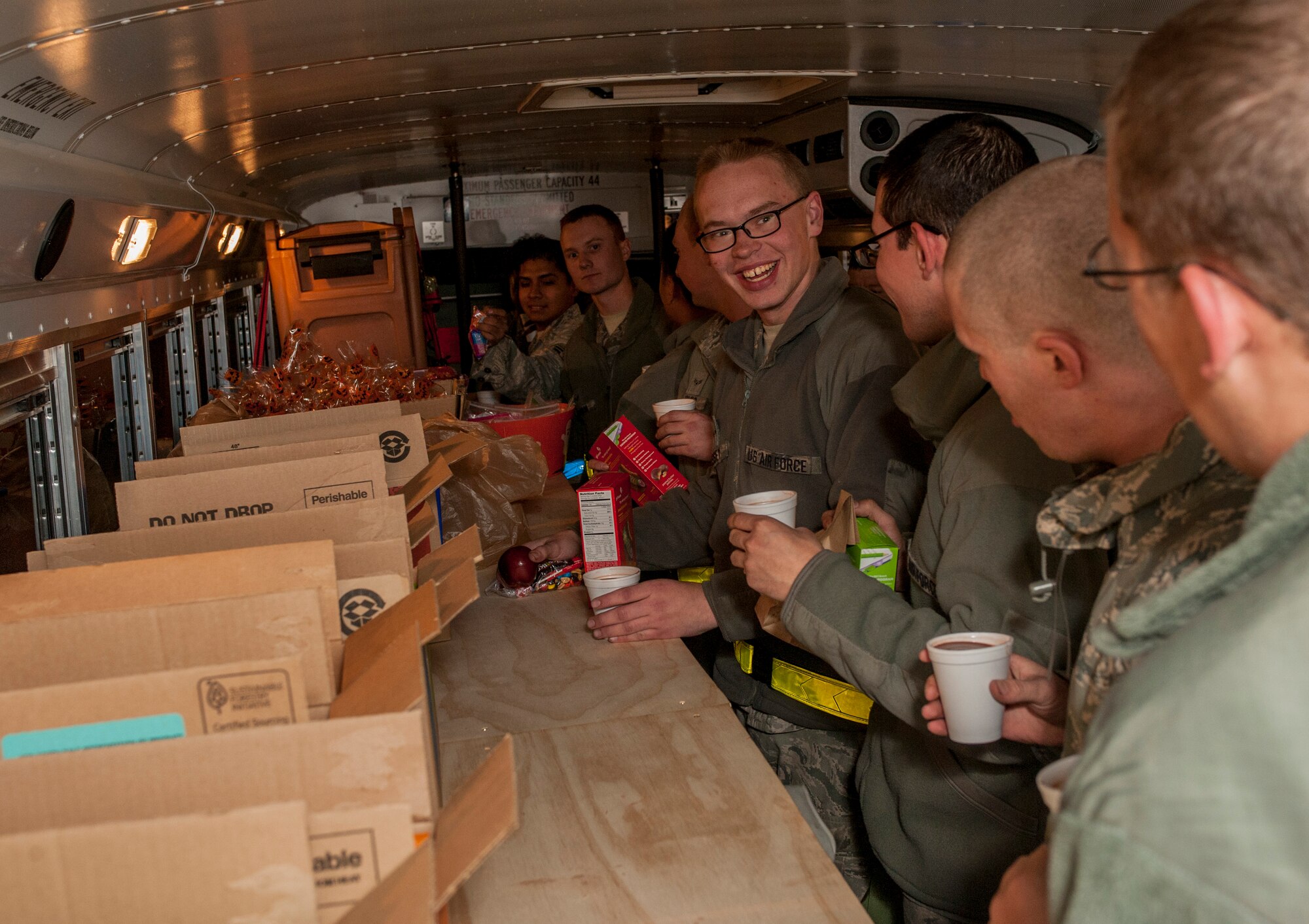 Airman 1st Class Robert Jones, 5th Aircraft Maintenance Squadron crew chief, laughs with his fellow crew coworkers while on the “cookie bus” at Minot Air Force Base, N.D., Oct. 31, 2013. The joy of the Airmen who were visited, and those who volunteered to deliver the late night treats, was evident in their faces. (U.S. Air Force photo/Senior Airman Stephanie Sauberan)