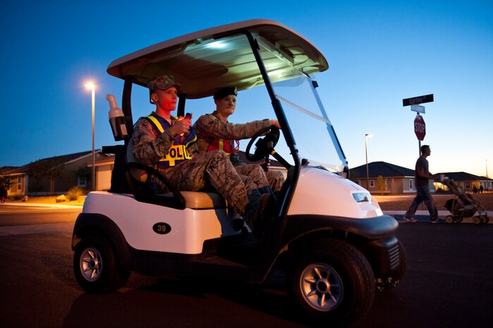 Airman 1st Class Charles Blanch, 57th Maintenance Squadron Precision Measurement Equipment Laboratory calibrations apprentice (left), patrols the base housing neighborhood with 99th Security Forces Squadron Armorer, Senior Airman Jeremiah Simmons (right), on the corner of Bartley Circle and John Chapman Parkway, Oct. 31, 2013, at Nellis Air Force Base, Nev. Airmen volunteered for the 99th SFS ‘Pumpkin Patrols’ program and teamed up with security forces to keep the streets safe for trick-or-treaters and their families for Halloween. (U.S. Air Force photo by Airman 1st Class Thomas Spangler)