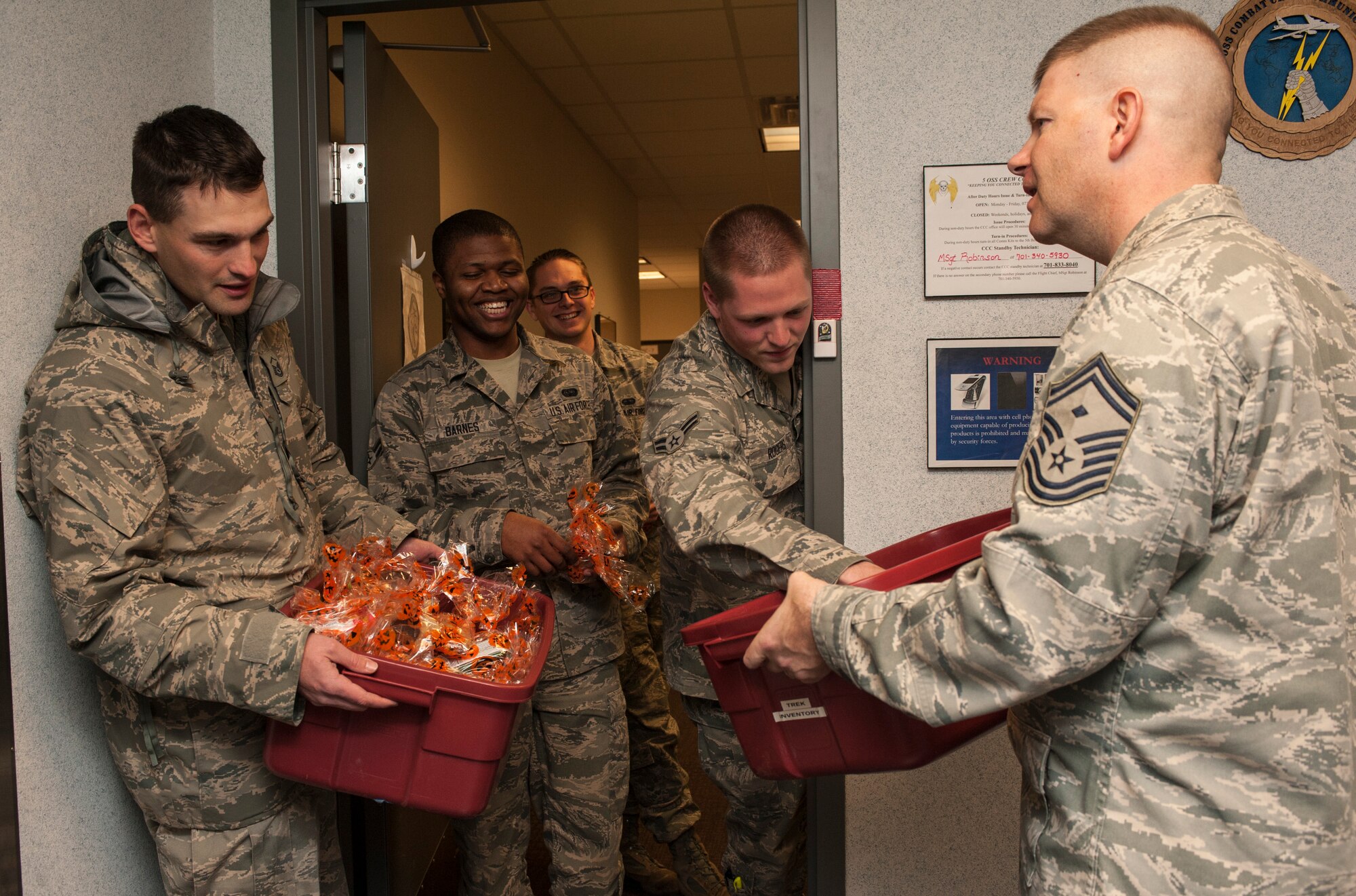 Team Minot first sergeants deliver a late night treat to Airmen assigned to the 5th Operations Support Squadron at Minot Air Force Base, N.D., Oct. 31, 2013. The group delivered cookies, apples and hot coco to Airmen working afternoon shifts on the flight line and at other 5th Bomb Wing support squadrons. (U.S. Air Force photo/Senior Airman Stephanie Sauberan)