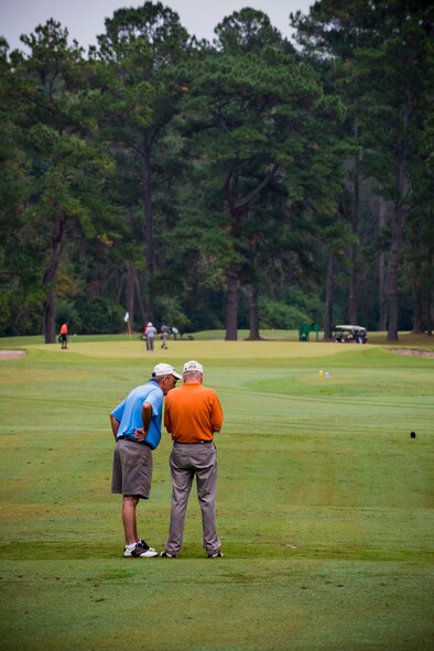Two teammates chat while waiting to tee off during the 2013 Retiree Appreciation Week Golf Tournament at Moody Air Force Base, Ga., Nov. 1, 2013. Each team consisted of four players who competed for overall lowest score in the scramble-style tournament. (U.S. Air Force photo by Staff Sgt. Jamal D. Sutter/Released)