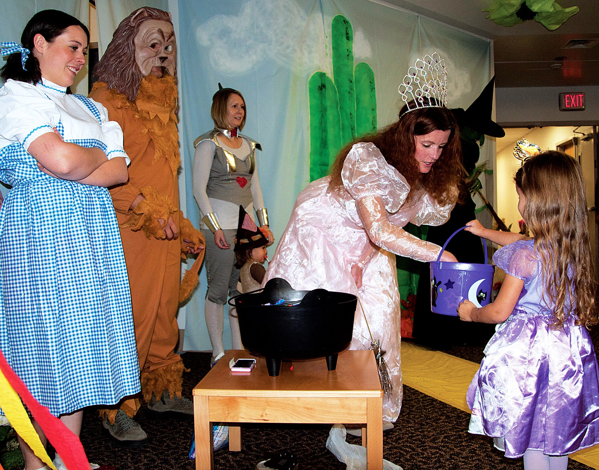 “Glinda, the Witch of the North,” Tech. Sgt. Sarah Hewitt, 90th Medical Operations Squadron, passes out candy to Ella, 4, daughter of Master Sgt. David Reed, 20th Air Force, as “Dorothy,” Staff Sgt. Bridget Fitzpatrick; “The Cowardly Lion,” 1st Lt. Yousif Nash; “The Tin Woodsman,” Tech. Sgt. Melissa Diaz; and “The Wicked Witch of the West,” Master Sgt. Stacy Hart; all with the 90th Medical Support Squadron; look on at the 90th Medical Group’s Halloween Event Oct. 31. The 90th MDG hosts a Halloween trick-or-treat event yearly in the clinic. Each section of the clinic had a theme such as the Wizard of Oz, Toy Story, Snow White and the Enchanted Forest, Scooby-Doo, a haunted house and much more. (U.S. Air Force photo by 1st Lt. Eydie Sakura)