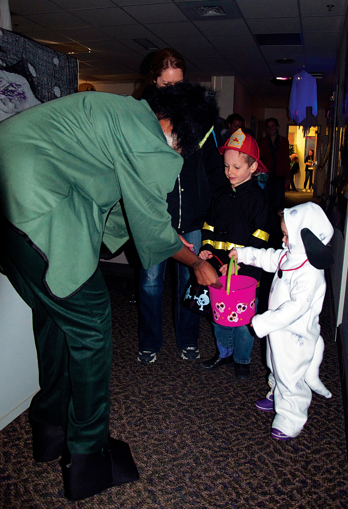 Grace, 3, and Zachary, 6, children of Staff Sgt. Paul Cameron, 790th Missile Security Forces Squadron, receive candy from “Frankenstein’s Monster,” Staff Sgt. Renee Know, 90th Medical Group, at the 90th MDG’s Halloween Event Oct. 31. The 90th MDG hosts a Halloween trick-or-treat event yearly in the clinic. Each section of the clinic had a theme such as the Wizard of Oz, Toy Story, Snow White and the Enchanted Forest, Scooby-Doo, a haunted house and much more. (U.S. Air Force photo by 1st Lt. Eydie Sakura)