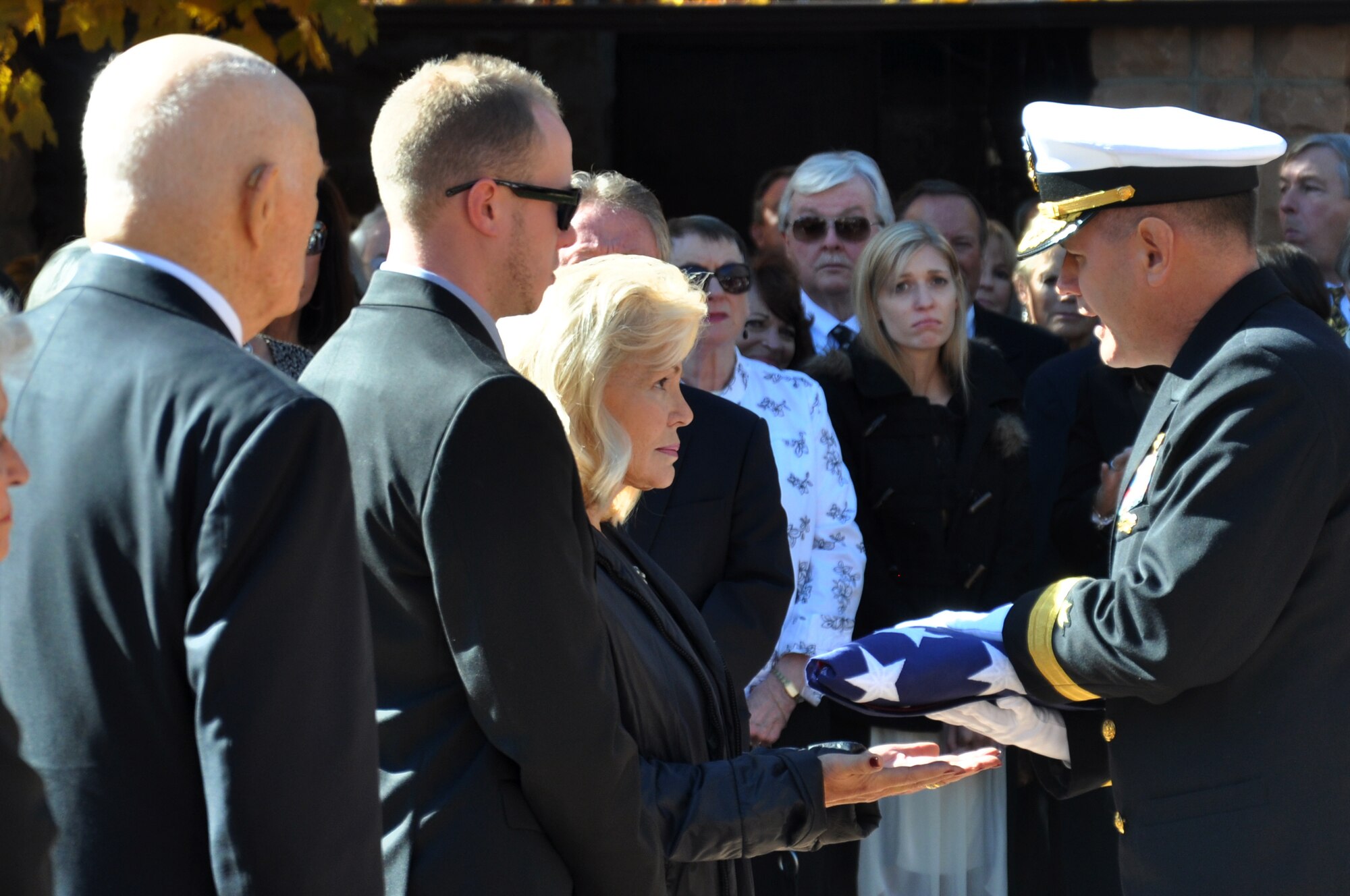 Patricia Carpenter, wife of retired Cmdr. Scott Carpenter, receives an American flag during his funeral for his military service Nov. 2, 2013, at St. John Episcopal Church in Boulder, Colo. Carpenter was the first human ever to hold the title of astronaut and aquanaut. He was the fourth American astronaut to fly in space and the second to orbit the Earth. (U.S. Air Force photo by Staff Sgt. Lucas Morrow/Released)