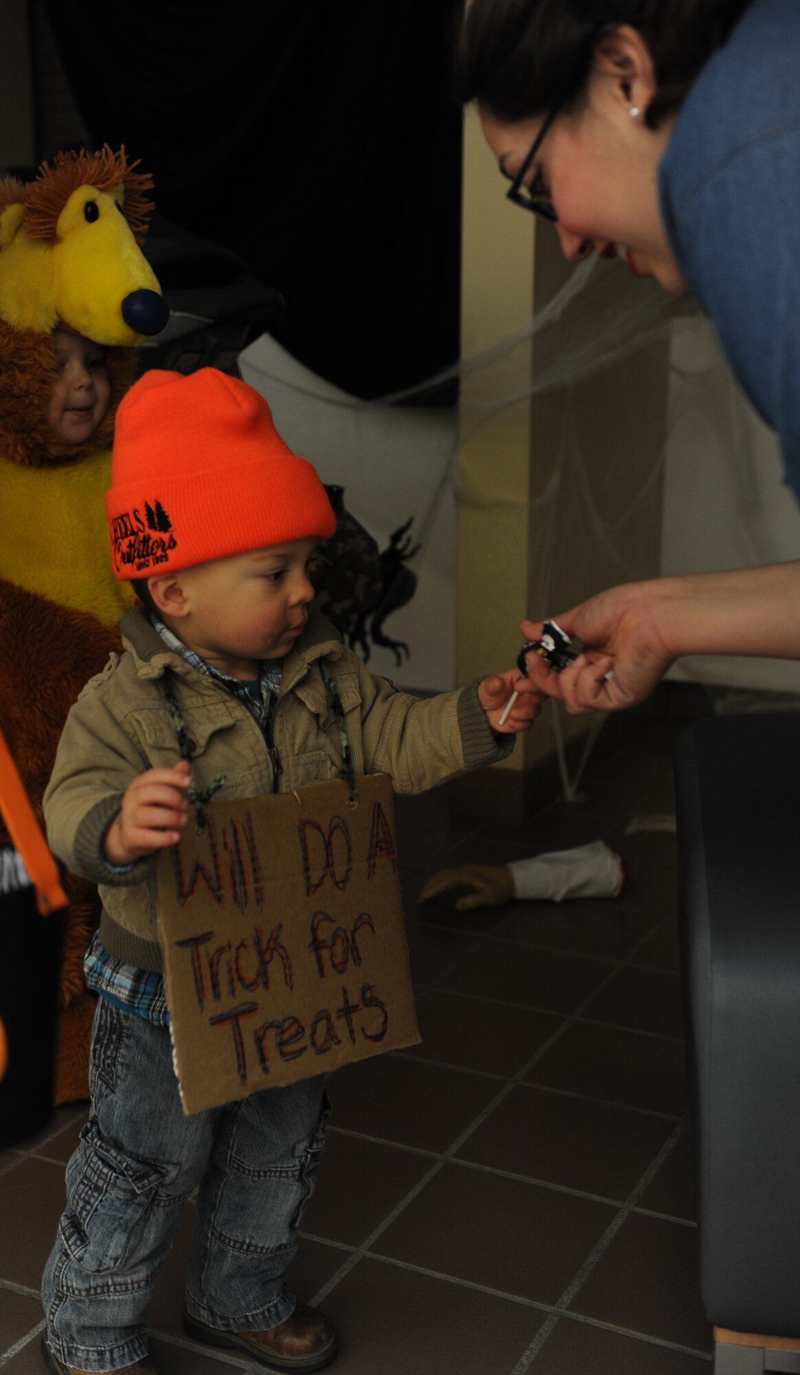 A young child receives candy during the Trail of Terror hosted at the 5th Medical Group, Oct. 31. Members from the 5th MDG dressed in Halloween costumes and escorted children and their families throughout the medical building, stopping from clinic to clinic. (U.S. Air Force photo/Airman 1st Class Lauren Pitts)