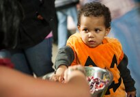 A child reaches for candy during the annual Trunk or Treat event, Oct. 31. The 5th Logistics Readiness Squadron Vehicle Operations teamed up with Balfour Beatty Communities this year to offer base residents free food and fun. (U.S. Air Force photo/Airman 1st Class Apryl Hall)