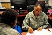 U.S. Air Force Senior Airman Alexis Allen, 4th Comptroller Squadron finance liaison to the 4th Operations and Maintenance Groups, assists a customer at Seymour Johnson Air Force Base, Oct. 28, 2013.  Allen helps according to a schedule, which fits the shifts of all 4th Maintenance and Operations Groups Airmen. (U.S. Air Force photo by Senior Airman Mariah Tolbert)