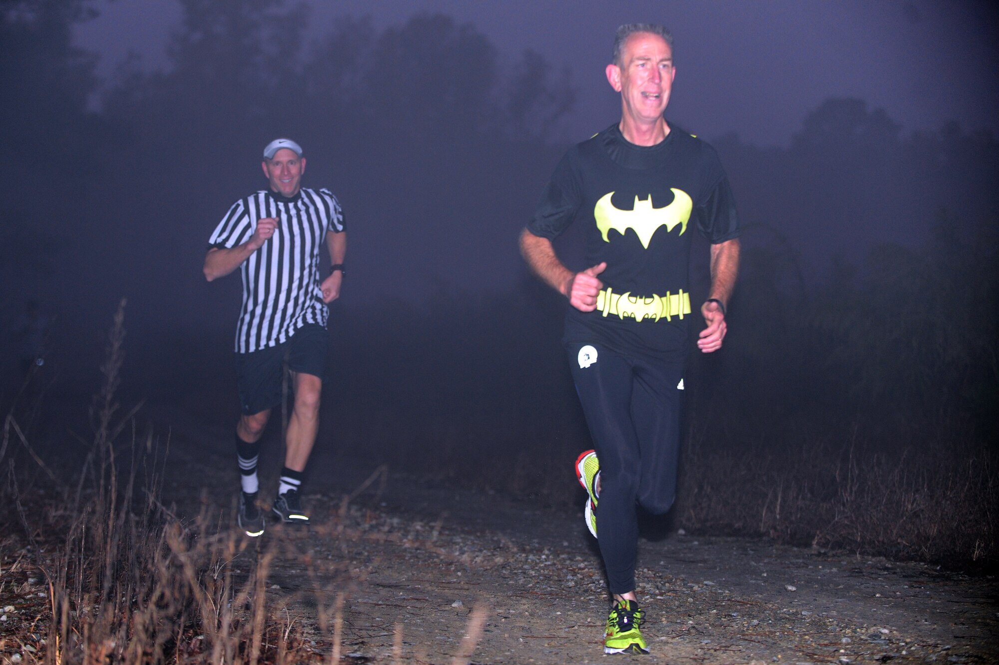David Nickell, 4th Operations Support Squadron mobility and security manager, runs ahead of U.S. Air Force Lt. Col. David Pike, 911th Air Refueling Squadron commander, through a thick fog during the Monster Dash 5k at Seymour Johnson Air Force Base, N.C., Oct. 31, 2013. Runners dressed up in costume to help boost Halloween spirit. (U.S. Air Force photo by Airman 1st Class John Nieves Camacho)