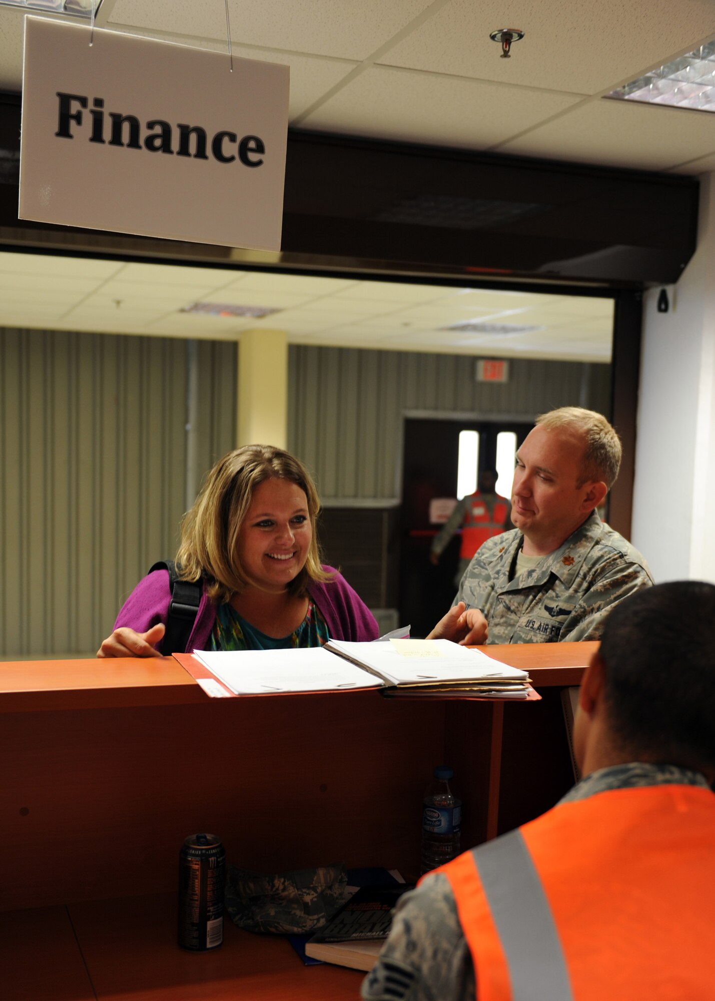 Jennifer Blount, 39th Air Base Wing spouse, and Maj. Keith Blount, 39th Air Base Wing director of inspections, speak with Senior Airman Ariel Fischer, 39th Comptroller Squadron customer service technician, about pay and finances during the noncombatant evacuation operation Oct. 30, 2013, at Incirlik Air Base, Turkey. The exercise tested the command and control, notification and passenger processing functions of a NEO. (U.S. Air Force photo by Senior Airman Chase Hedrick/Released)
