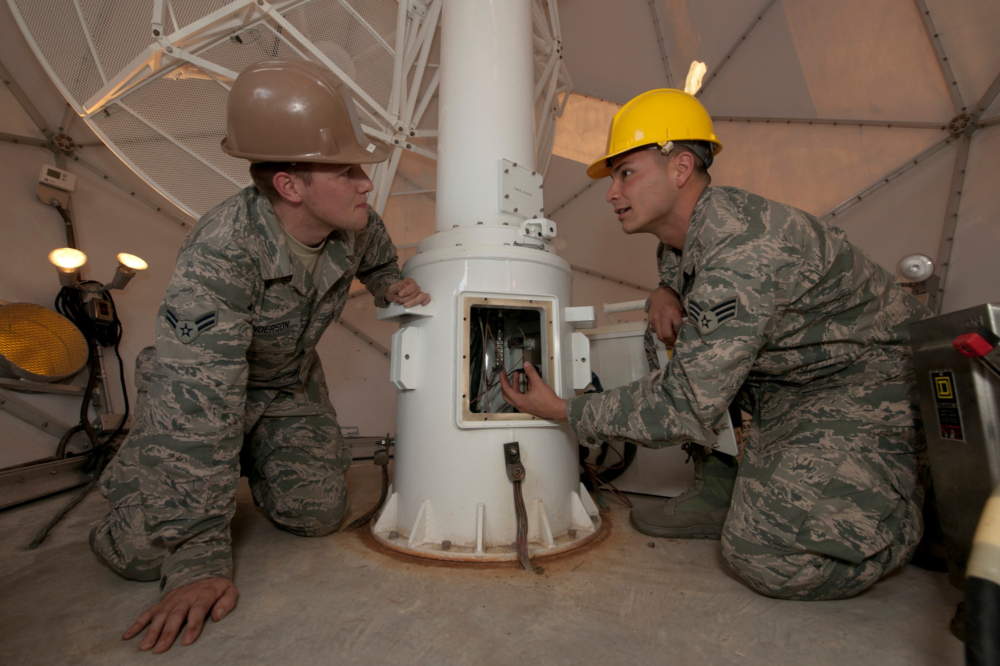U.S. Air Force Airman 1st Class Michael Gunderson, left, listens to Senior Airman Frederick Rosario explain what to inspect at the base of the MARK IVB Weather System during an 84-day preventive maintenance inspection Oct. 31, 2013, at Lajes Field, Azores. The weather system provides real-time, mid-Atlantic weather imagery and services to more than 2,000 users at more than 250 locations. The Airmen are radio frequency systems technicians with the 65th Communications Squadron. (U.S. Air Force photo by Tech. Sgt. Paul Villanueva II/Released)