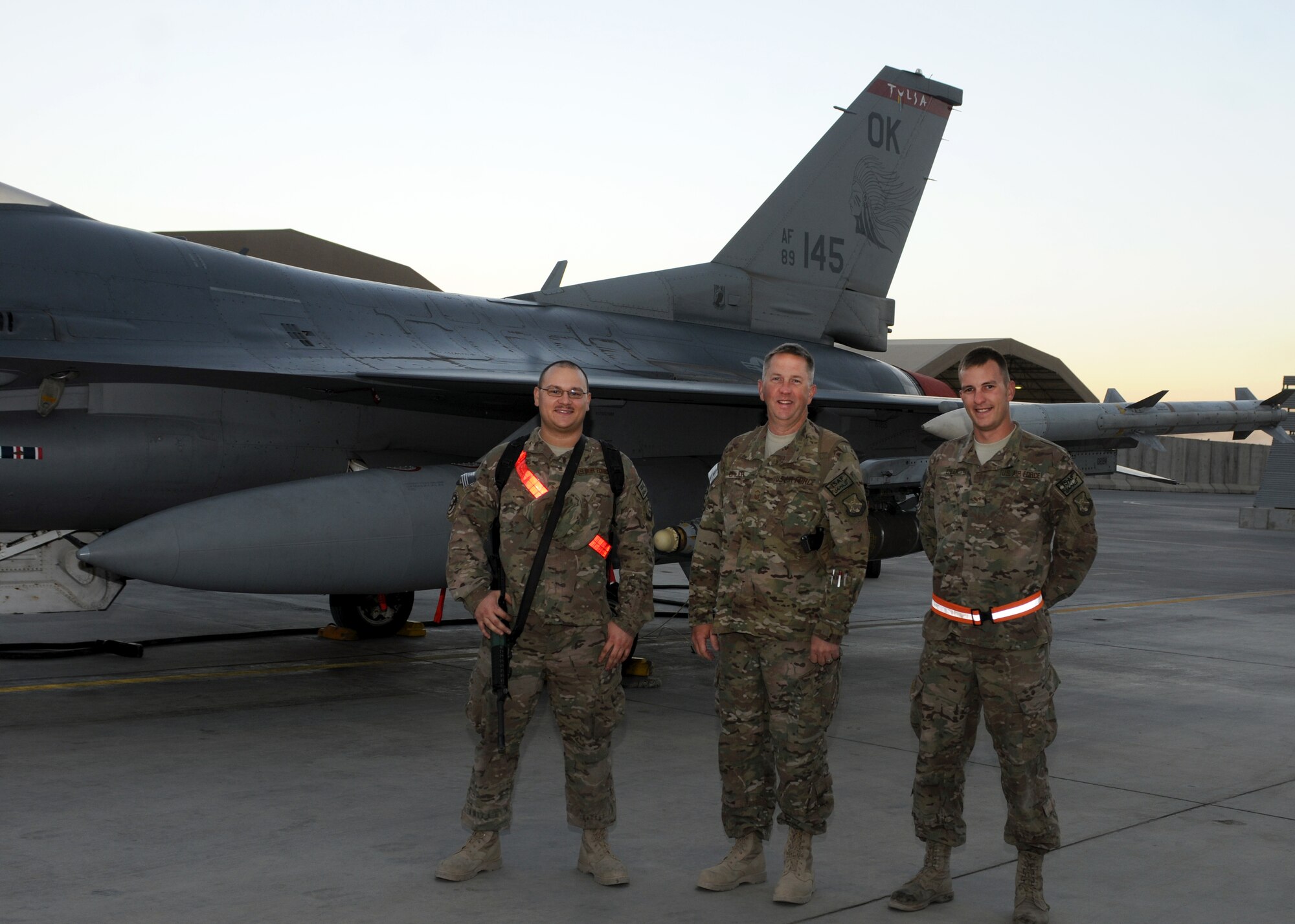 Senior Airman Michael Stevens (left), Senior Master Sgt. Eric Erler (middle) and Senior Airman Brandon Erler (right) stand in front of an F-16 Fighting Falcon at Kandahar Airfield, Afghanistan, Oct. 8, 2013. All three Airmen are deployed to Kandahar from the 138th Fighter Squadron in Tulsa, Okla, and are members of the same family. (U.S. Air Force photo illustration by Senior Airman Jack Sanders)