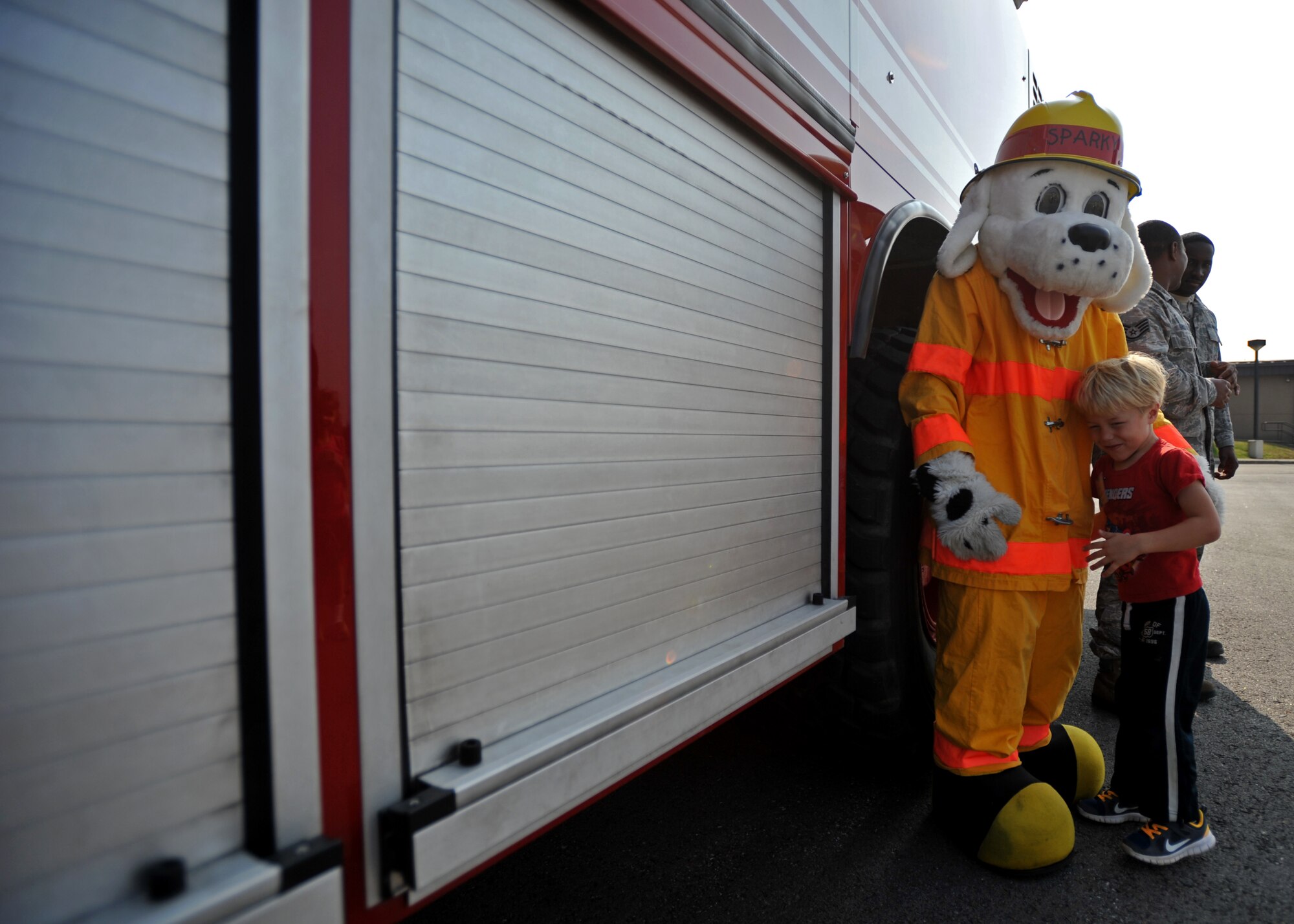 Sparky the Fire Dog hugs a U.S. and Republic of Korea Family Day participant at Osan Air Base, ROK, Nov. 1, 2013. Sparky and firefighters from the 51st Civil Engineer Squadron let active duty members and dependents tour the inside of a fire truck and also demonstrated how to use the water hose. (U.S. Air Force photo/Senior Airman Siuta B. Ika)
