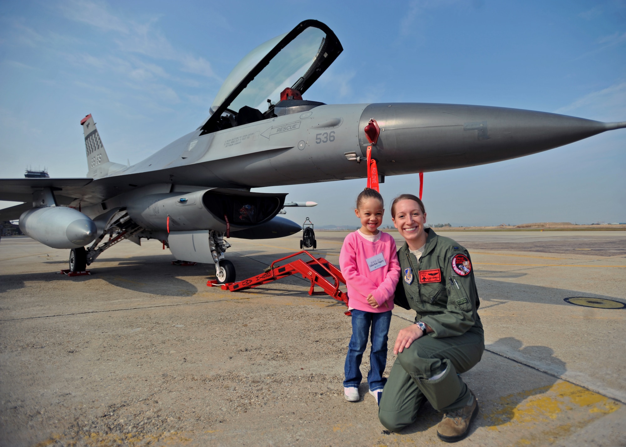 Gillian-Rose Hagarty, 5, poses for a photo with 1st Lt. Clancy Morrical, 36th Fighter Squadron F-16 Fighting Falcon pilot, during a U.S. and Republic of Korea Family Day at Osan Air Base, ROK, Nov. 1, 2013. Gillian-Rose is the daughter of Senior Master Sgt. Paul Hagarty, 51st Aerospace Medicine Squadron superintendent. (U.S. Air Force photo/Senior Airman Siuta B. Ika)