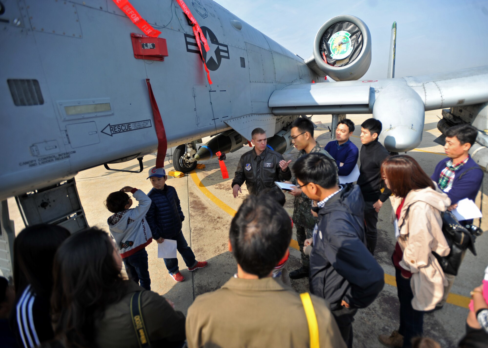 Capt. Aaron Bigler, 25th Fighter Squadron A-10 Thunderbolt pilot, speaks to active duty members and dependents during a U.S. and Republic of Korea Family Day at Osan Air Base, ROK, Nov. 1, 2013. Bigler spoke to more than 50 participants during the event about the A-10’s weapons and capabilities. (U.S. Air Force photo/Senior Airman Siuta B. Ika)