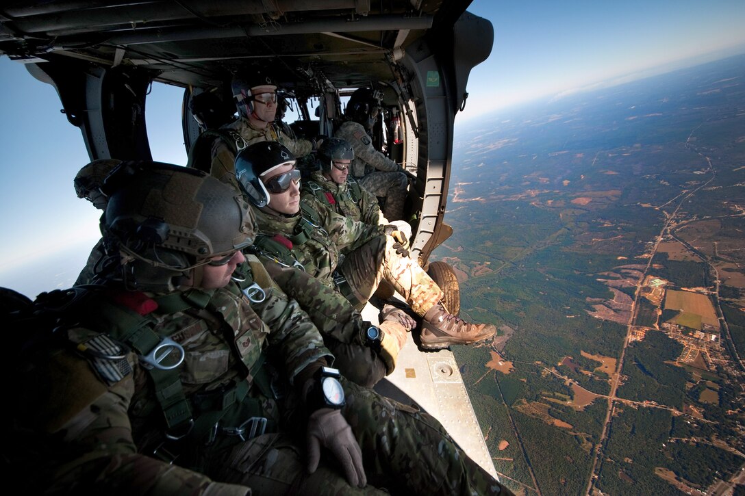 From left to right, Air Force Tech. Sgt. Stewart Ferguson, Air Force Capt. Casey Griffin and Army Sgt. 1st Class Nelson Ashbrook sit in a UH-60 Black Hawk helicopter as it climbs to 10,000 feet above Fort Benning to prepare for a high-altitude, low-opening jump during the reconnaissance surveillance course for leaders over Fort Benning, Ga., Oct. 25, 2013. Ashbrook is assigned to 316 Cavalry Brigade and Casey is assigned to the 17th Special Tactics Squadron. 