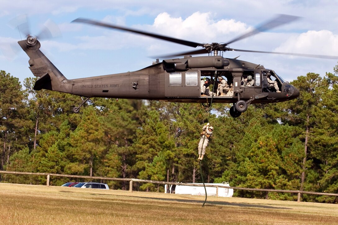 Army 2nd Lt. Justin Holmes works his way down a rope as he fast-ropes from a UH-60 Black Hawk helicopter during phase one of the reconnaissance surveillance course for leaders on Fort Benning, Ga., Oct. 28, 2013. Holmes is assigned to the 201st Battlefield Surveillance Brigade, 3rd Squadron, 38th Cavalry Regiment.