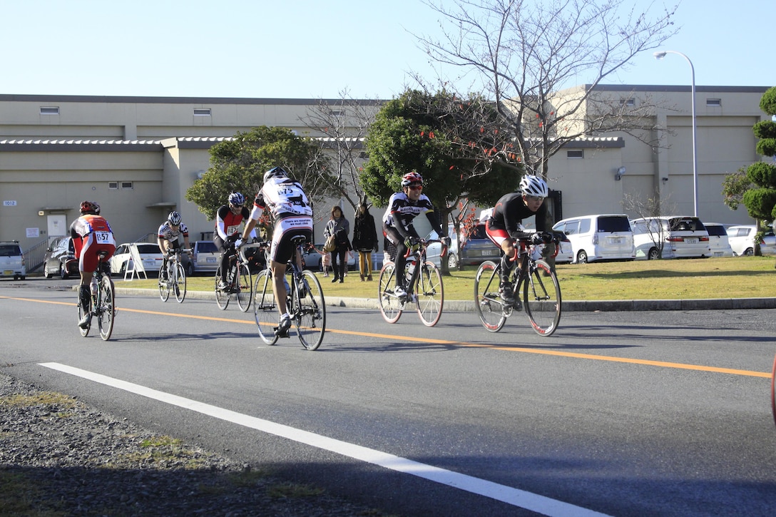 Athletes pass IronWorks Gym here during their bike route for the 2011 Heat the Streets Duathlon that took place here Sunday. Participants were spread out across the grass in front of IronWorks Sunday morning before the race started, stretching out to prepare for the challenge ahead. The Duathlon is an annual event sponsored by Marine Corps Community Services Iwakuni to strengthen bonds between station residents and Japanese locals. Besides Friendship Day, the races MCCS Iwakuni sponsors are the best way to allow locals access to the station. Participants started the race in front of IronWorks Gym with a four kilometer run to Penny Lake fields and back on the seawall. Participants then changed over to their bikes inside the bike rack area for a 24-kilometer biking portion. The last part of the race had participants place their bikes back in the racks and run for another four kilometers from the seawall to Penny Lake fields, finishing in front of IronWorks. 

