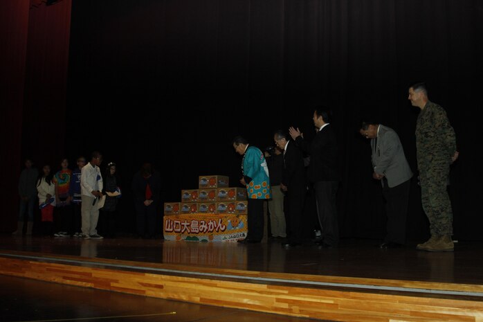 Matthew C. Perry Elementary School student counsel members bow in appreciation to Yoshihiko Fukudo, Iwakuni City mayor, Lt. Col. P.J. Kerr, Marine Corps Air Station Iwakuni executive officer, other distinguished guests and community leaders for the Mikans given during the 2nd annual Mikan Exchange at the Sakura Theater here Dec. 15. The Mikan fruit exchange gave the M.C. Perry children a taste, literally, of Japanese culture.