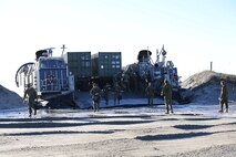 Service members with the 26th Marine Expeditionary Unit depart a Landing Craft Air Cushion during offloading operations at Onslow Beach, Camp Lejeune, N.C., Nov. 03, 2013. Marines and sailors with Combat Logistics Battalion 26, 2nd Marine Logistics Group and other elements from the 2nd Marine Expeditionary Force supported the 26th MEU in operations throughout the Mediterranean. (U.S. Marine Corps photo by Lance Cpl. Shawn Valosin)