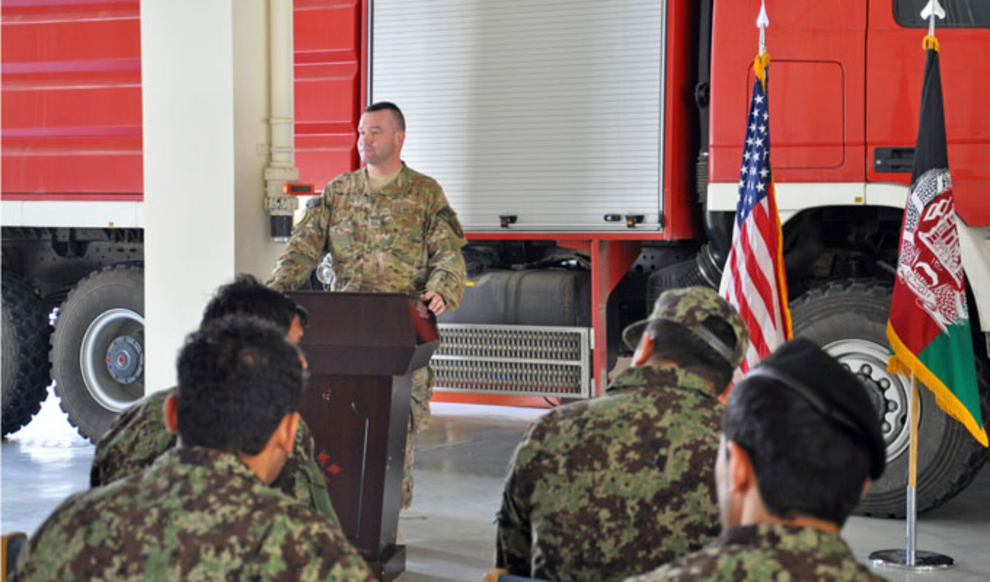 Master Sgt. Jeffery Hackworth addresses graduates of the first Afghan Fire Instructor Course during a ceremony Oct. 31, 2013 at Kabul International Airport, Afghanistan. The five-day class was developed by NATC-A advisors and graduated 13 Afghan Air Force and Afghan National Army firefighters as certified instructors. The graduates can now certify additional firefighters at their home fire stations. Hackworth is the NATO Air Training Command-Afghanistan fire adviser.
