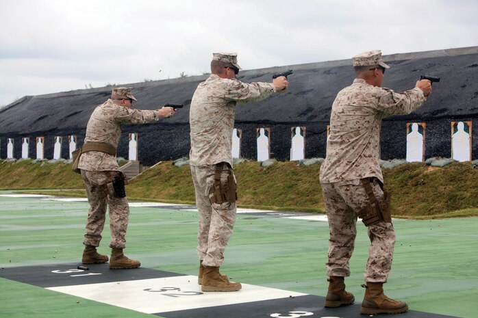From left to right, Chief Warrant Officer Christopher D. Jay, Capt. Sean D. Wills and Gunnery Sgt. John C. O’Neal IV execute a drill during the combat pistol program Oct. 29 at Range 15 on Camp Hansen. Jay is a chemical, biological, radiological, and nuclear defense officer with Headquarters Battalion, 3rd Marine Division, III Marine Expeditionary Force, Wills is the executive officer with Communication Company, 3rd Marine Division, III MEF, and O’Neal is a satellite maintenance chief with 7th Communication Battalion, III MEF Headquarters Group, III MEF.