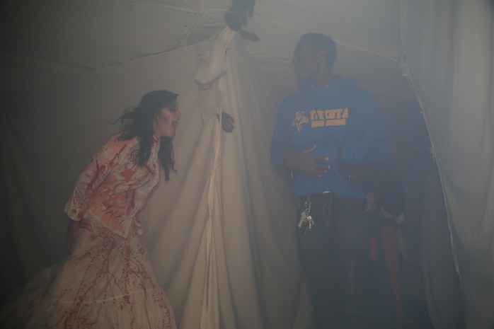 Lance Cpl. Alexandria Bogan, a motor transportation operator with Marine Wing Support Squadron 171, stands behind a corner inside the MWSS-171 haunted house to give guests a good, quality scare, Oct. 31, 2013. Marines volunteering as staff for the haunted house were not bound to one spot and floated through the tour to scare each group multiple times.