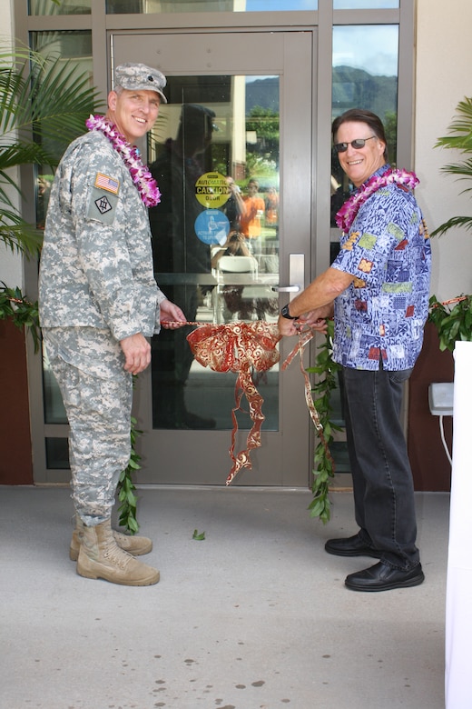 Honolulu District Commander Lt. Col. Thomas D. Asbery (left) assists Robert Eastwood, Director, Directorate of Public Works, USAG-Hawaii cut the   ceremonial ribbon during ceremonies held Oct. 30 to open the new $35.3 million barracks on Montague Street. The new six-story facility will house Soldiers of Headquarters and Headquarters Battalion, 25th Infantry Division (25th ID) and 2nd Brigade. 