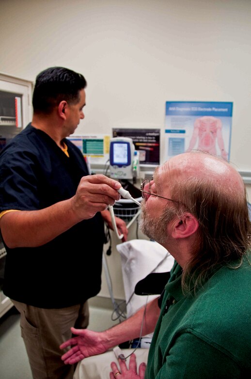Madigan-South Sound Community Medical Home employees Marco Anaya, LPN, (left) and Gary Brosier, PA, demonstrate basic patient care practices during the open house and ribbon cutting in March.  