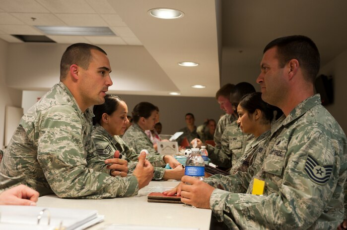 Capt. Robert Miller (left), U.S. Air Force Warfare Center assistant staff judge advocate, speaks to Tech. Sgt. Kenneth Parrish (right), 99th Logistics Readiness Squadron NCO in charge of customer service, during an operational readiness exercise Nov. 5, 2013, at Nellis Air Force Base, Nev. The exercise tested the 99th Air Base Wing's capability to deploy personnel, weapon systems and equipment to perform its mission worldwide. (U. S. Air Force photo by Airman 1st Class Christopher Tam)