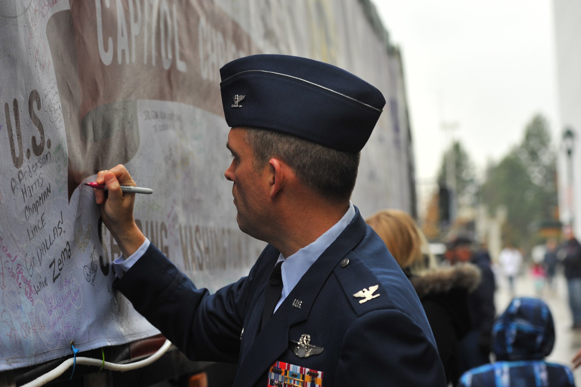Col. Brian Newberry, 92nd Air Refueling Wing commander, signs the tarp that covers the 2013 U.S. Capitol Christmas Tree at the INB Performing Arts Center in downtown Spokane, Wash., Nov. 5. The tree began its journey at the Colville National Forest in Washington Nov. 1, and will visit 22 cities on its way to Washington, D.C., arriving on November 25th. Spokane was the tree’s second stop. (U.S. Air Force photo by Staff Sgt. Veronica Montes)
