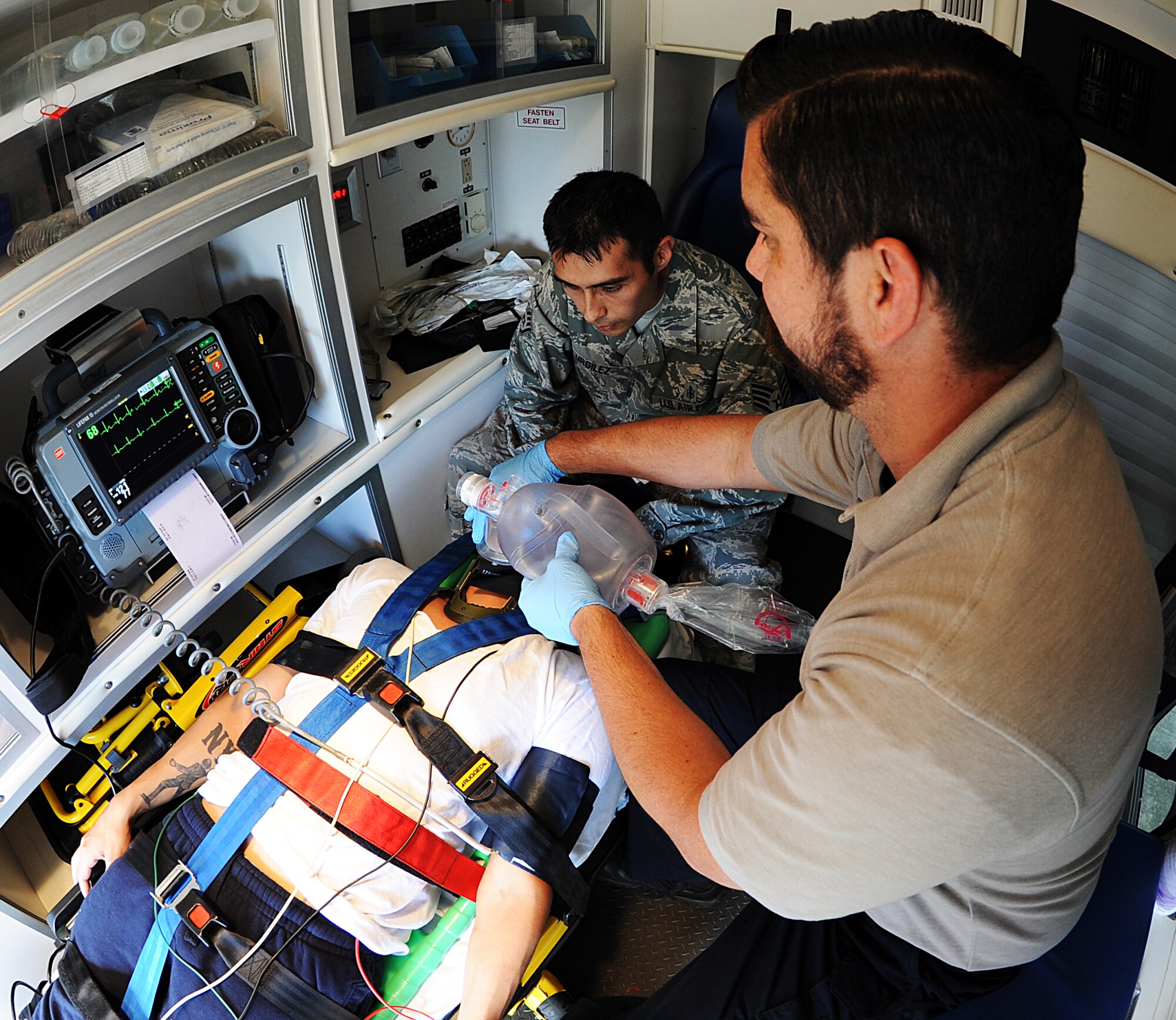 Staff Sgt. Angel Urgilez and Joshua Conley, 1st Special Operations Medical Operations Squadron paramedics, simulate providing oxygen to a patient in the back of an ambulance at Hurlburt Field, Fla., Nov. 5, 2013. Urgilez uses simulations to refresh the certified paramedics on his stafff and train new Airmen on practical application of skills they learned in technical training.