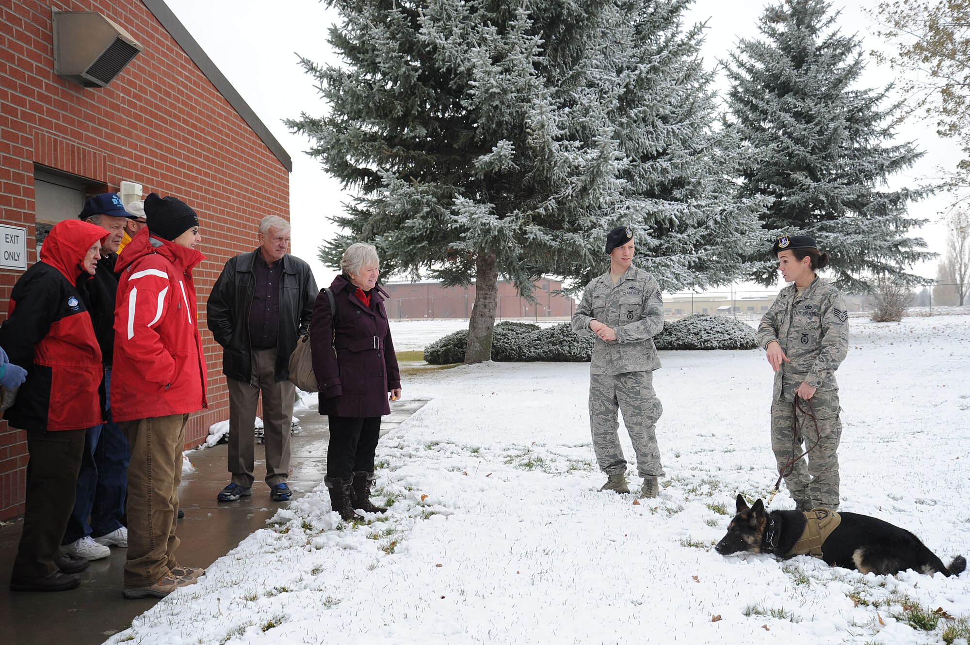 Tech. Sgt. Thomas Winn and Staff Sgt. Melissa Schmalhorst, both 92nd Security Forces Squadron Military Working Dog handlers, speak with Rotary Spokane West members about Military Working Dogs during a tour at Fairchild Air Force Base, Wash., Nov. 5, 2013. (U.S. Air Force photo by Airman 1st Class Janelle Patiño/Released)