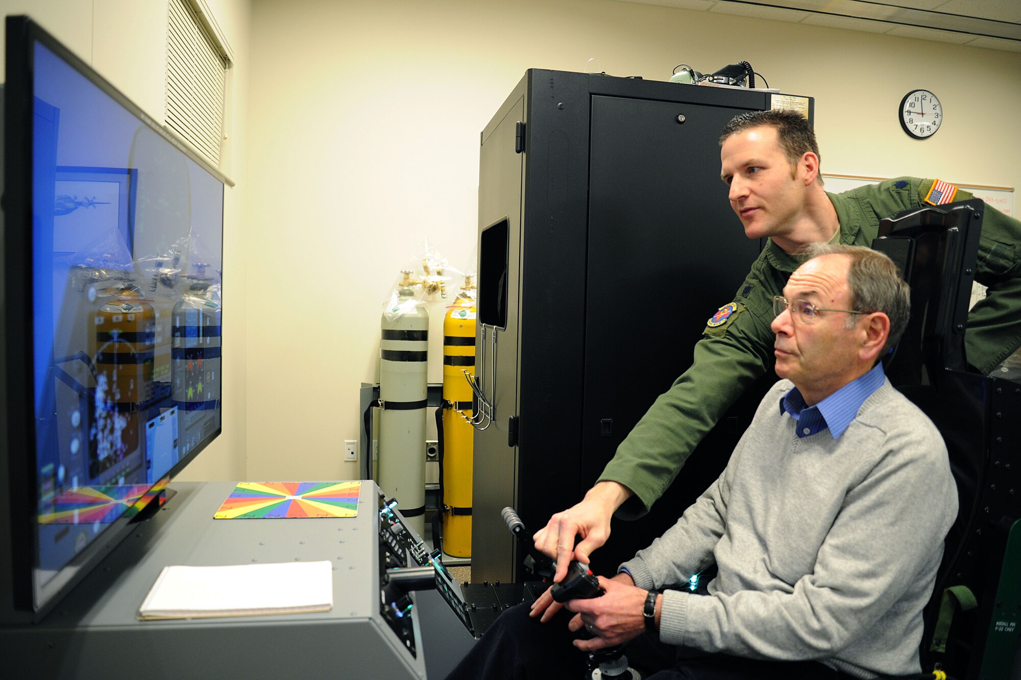 Lt. Col. Matthew Albright, 92nd Aerospace Medicine Squadron wing aerospace physiologist, instructs a member from Rotary Spokane West on an aircraft piloting simulator during a tour at Fairchild Air Force Base, Wash., Nov. 5, 2013. (U.S. Air Force photo by Airman 1st Class Janelle Patiño/Released)
