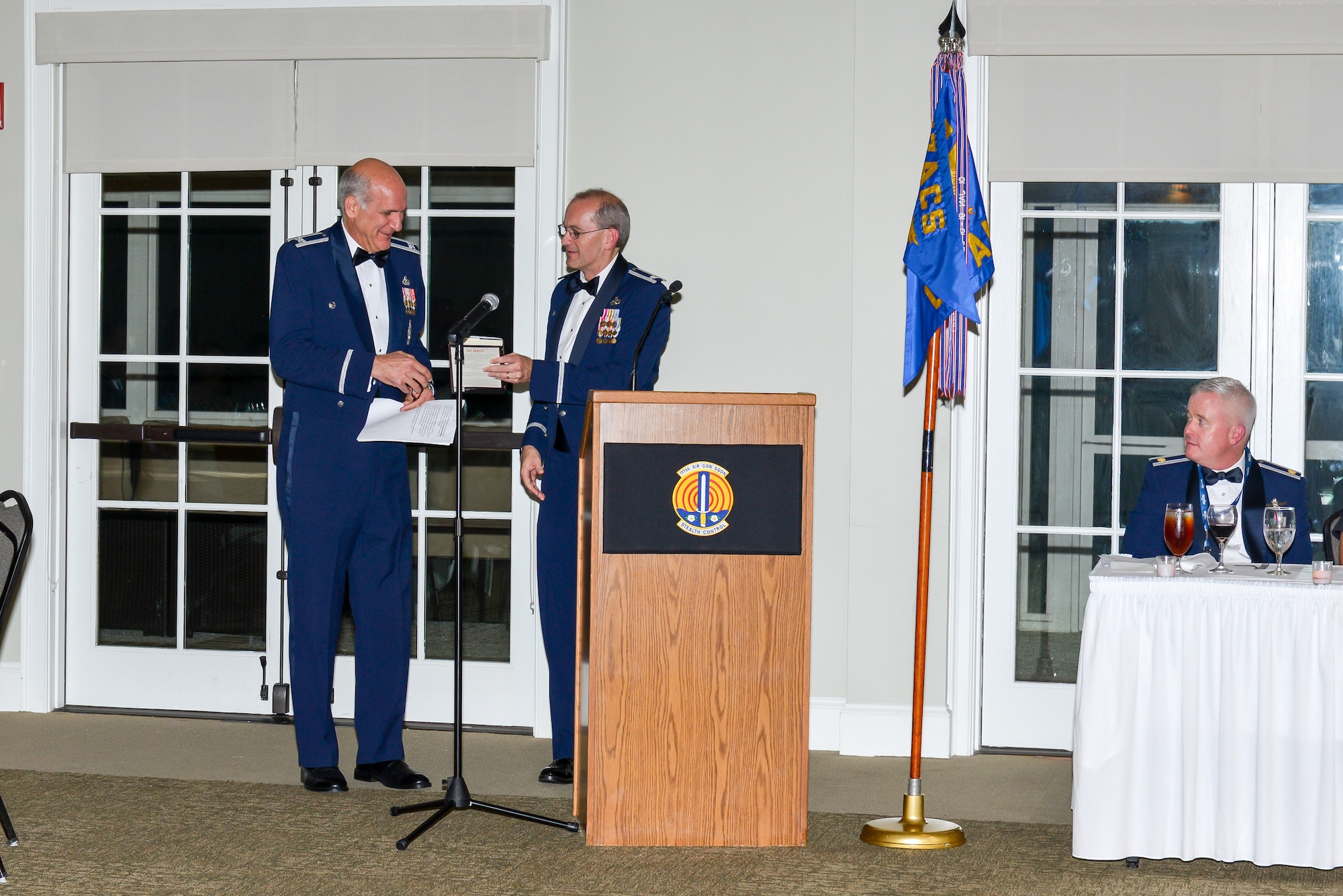 U.S. Air Force Lt. Col. Ron Speir of the 117th Air Control Squadron, Georgia air National Guard, presents a book to retired Col. Joe Ferrero during a Dining Out, Nov. 1, 2013, at the Richmond Hill City Center in Richmond Hill, Ga. Ferrero was the guest speaker during the dinner which consisted of Airmen and familiy members of the 117th ACS.(Georgia Air National Guard photo by Tech. Sgt. Charles Delano/released)