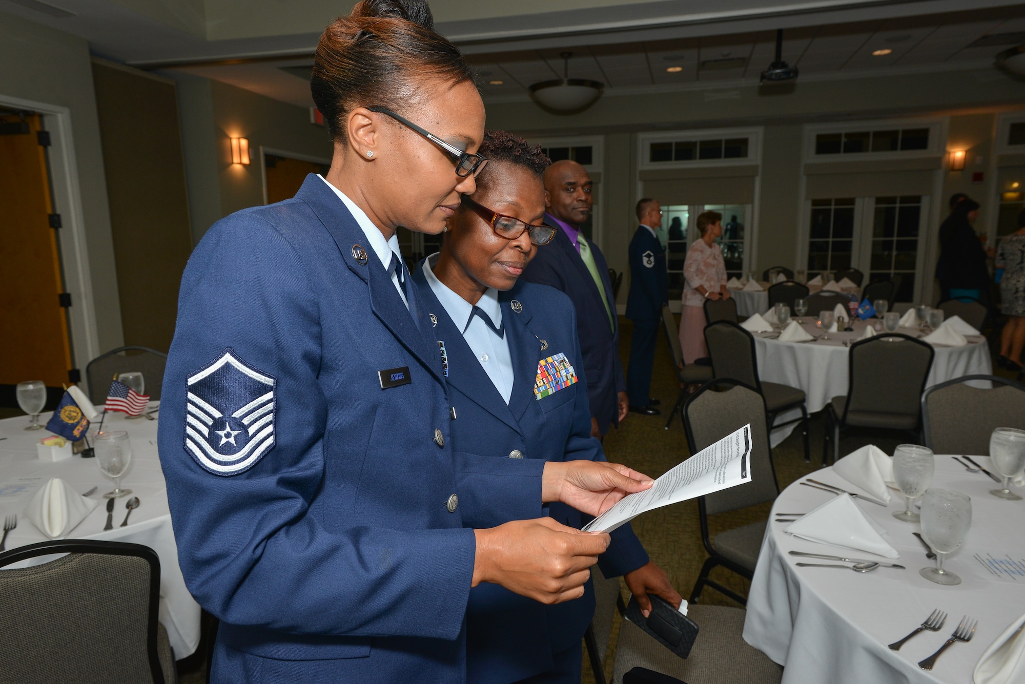 Air National Guard Master Sgt. Gequetta Jenkins and Senior Master Sgt. Michelle Massey from the 117th Air Control Squadron read the mess rules during a Dining Out, November 1, 2013, at the Richmond Hill City Center in Richmond Hill, Ga. The Air Force Dining Out provides a venue for Airmen and families to enhance espirit de corps and reinforce Air Force tradition. (U.S. Air National Guard photo by Tech. Sgt. Charles Delano/released)