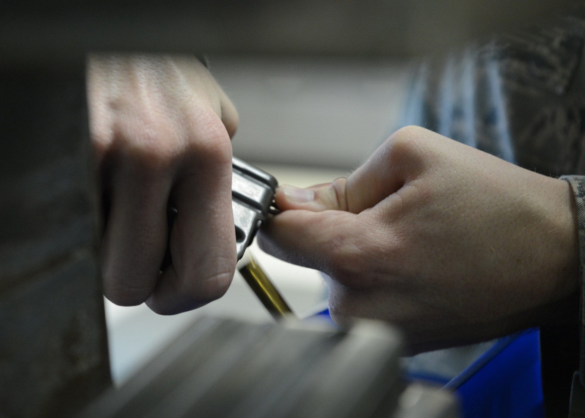 U.S. Air Force Airman 1st Class David Bowman, 20th Security Forces Squadron security forces journeyman, strips rounds from a magazine at Shaw Air Force Base, S.C., Oct. 15, 2013. Bowman  removed the rounds to inspect their serviceability. (U.S. Air Force photo by Tech. Sgt. Frank Miller/Released)
