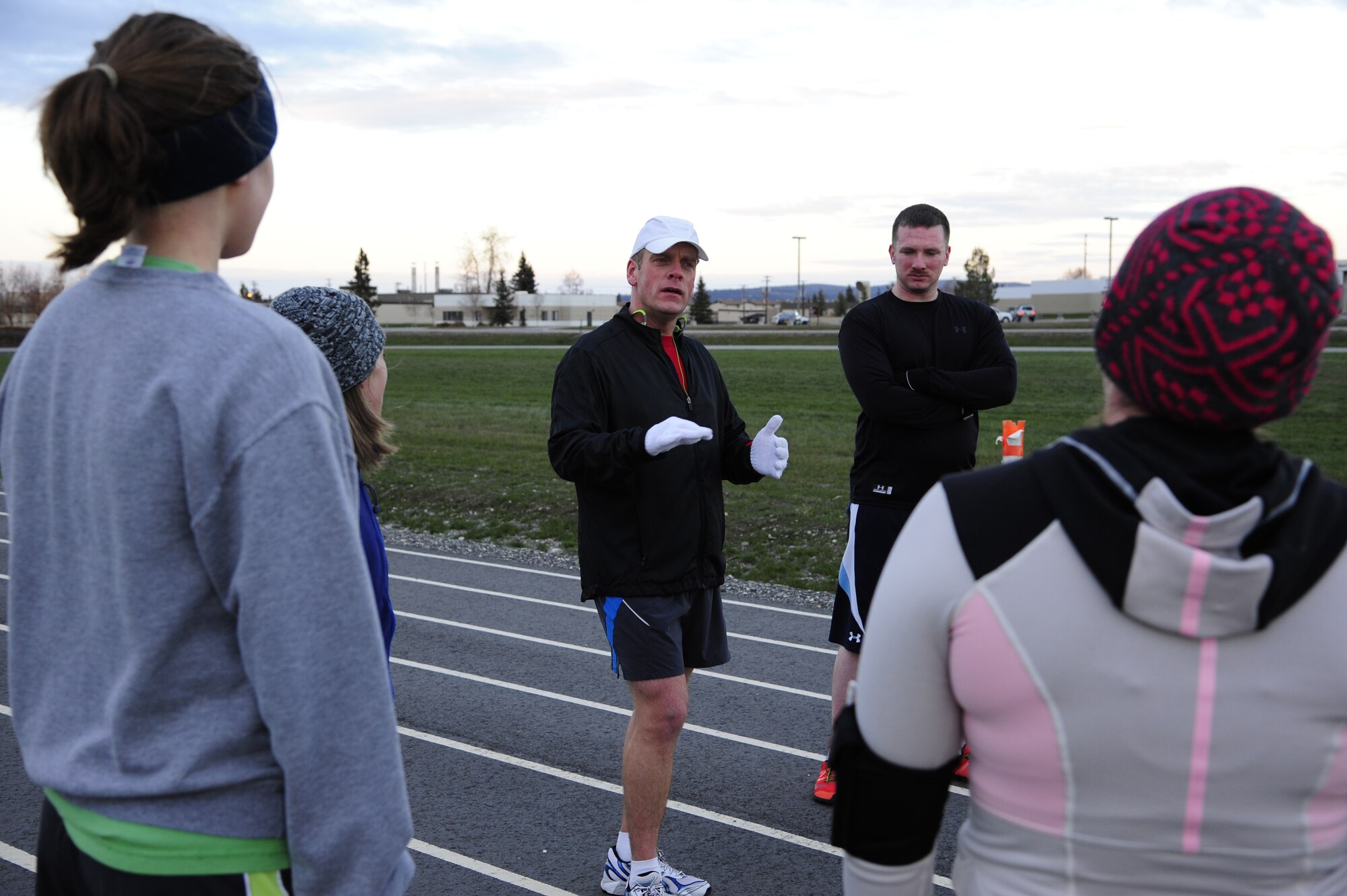 Col. Jay Aanrud, 354th Fighter Wing vice commander, briefly chats with participants about running fitness after a workout on the outdoor track Oct. 25, 2013, Eielson Air Force Base, Alaska. The running group is open to anyone and typically meets at noon on Fridays. For additional information on running or other fitness activities, visit the fitness center or call the Health and Wellness Center at 377-9355. (U.S. Air Force photo by Senior Airman Zachary Perras)