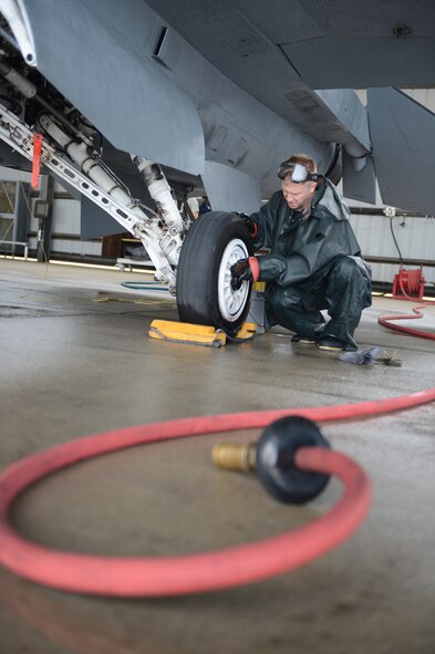 U.S. Air Force Staff Sgt. Alan Dorman, 55th Aircraft Maintenance Squadron tactical aircraft maintainer, scrubs the landing gear of an F-16 Fighting Falcon, Oct. 28, 2013, at Shaw Air Force Base, S.C. During the cleaning, the jet is scrubbed down from top to bottom including the landing gear.  (U.S. Air Force photo by Tech. Sgt. Frank Miller/Released)