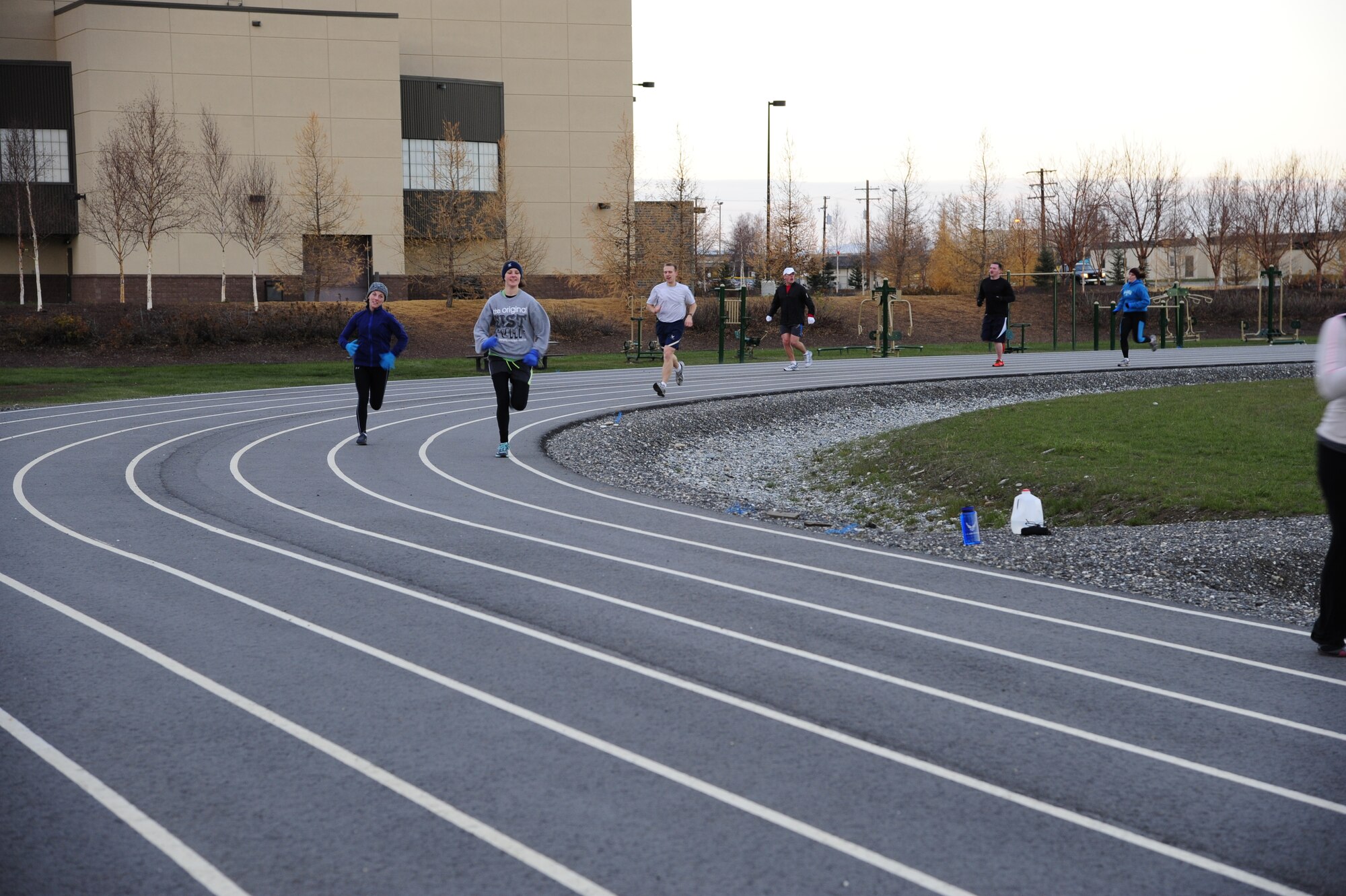 Participants in a running group make their way around the outdoor track during a workout Oct. 25, 2013, Eielson Air Force Base, Alaska. The running group is open to anyone and typically meets at noon on Fridays. For additional information on running or other fitness activities, visit the fitness center or call the Health and Wellness Center at 377-9355. (U.S. Air Force photo by Senior Airman Zachary Perras)