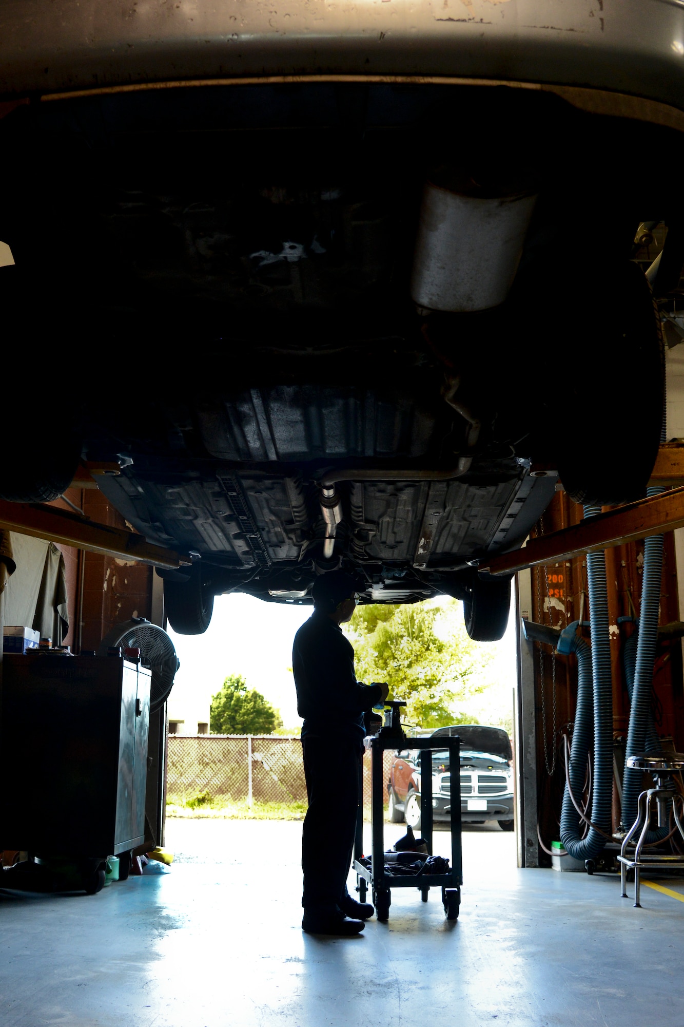 Dyna Nam, a contracted mechanic, performs maintenance on a customer's vehicle on a lift at the Auto Skills Shop at Langley Air Force Base, Va., Nov. 5, 2013. The Auto Skills Shop's staff of three full-time mechanics performs a variety of automotive repair services on weekdays from 8 a.m. to 5:30 p.m. (U.S. Air Force photo by Senior Airman Jason J. Brown/Released)