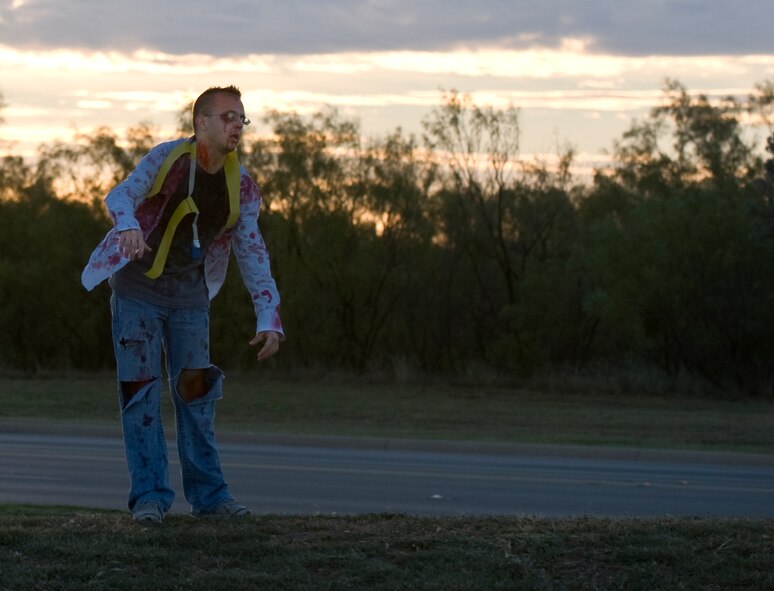 U.S. Air Force Staff Sgt. Jeremiah Hunter, 7th Logistics Readiness Squadron, stands on top of a hill to get a better vantage point during the Post-Apocalyptic Relay Oct. 31, 2013, at Dyess Air Force Base, Texas. Several Airmen volunteered to play the role of zombies, who attempted to infect runners through the course by grabbing flags around their waists. (U.S. Air Force photo by Senior Airman Peter Thompson/Released)