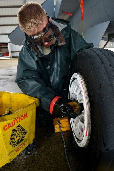 U.S. Air Force Senior Airman Brad Pippin, 20th Aircraft Maintenance Squadron tactical aircraft maintainer, scrubs the wheel of an F-16 Fighting Falcon during a routine cleaning, Shaw Air Force Base, S.C., Oct. 28, 2013. During the cleaning, the jet is scrubbed down from top to bottom including the landing gear. (U.S. Air Force photo by Airman 1st Class Jensen Stidham/Released)